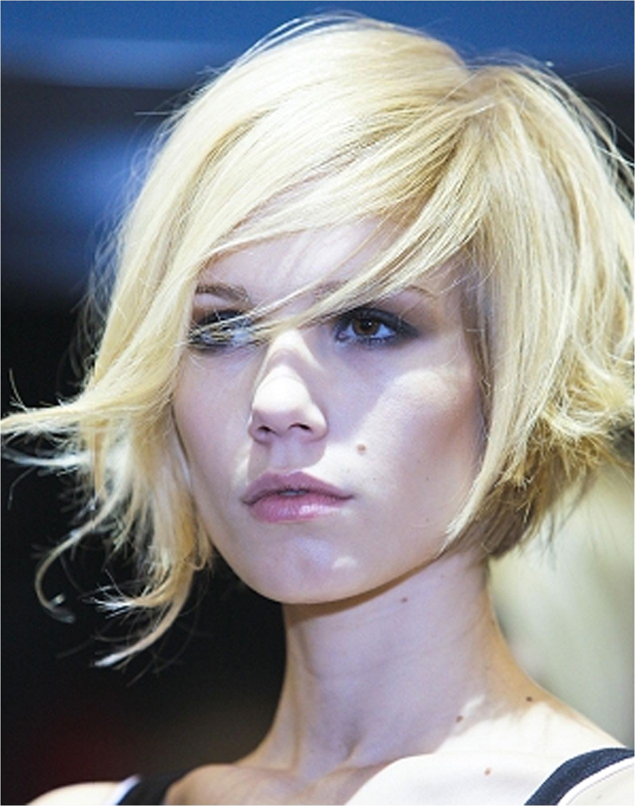 Blonde asymmetrical bob haircut with long side swept bangs hairstyle