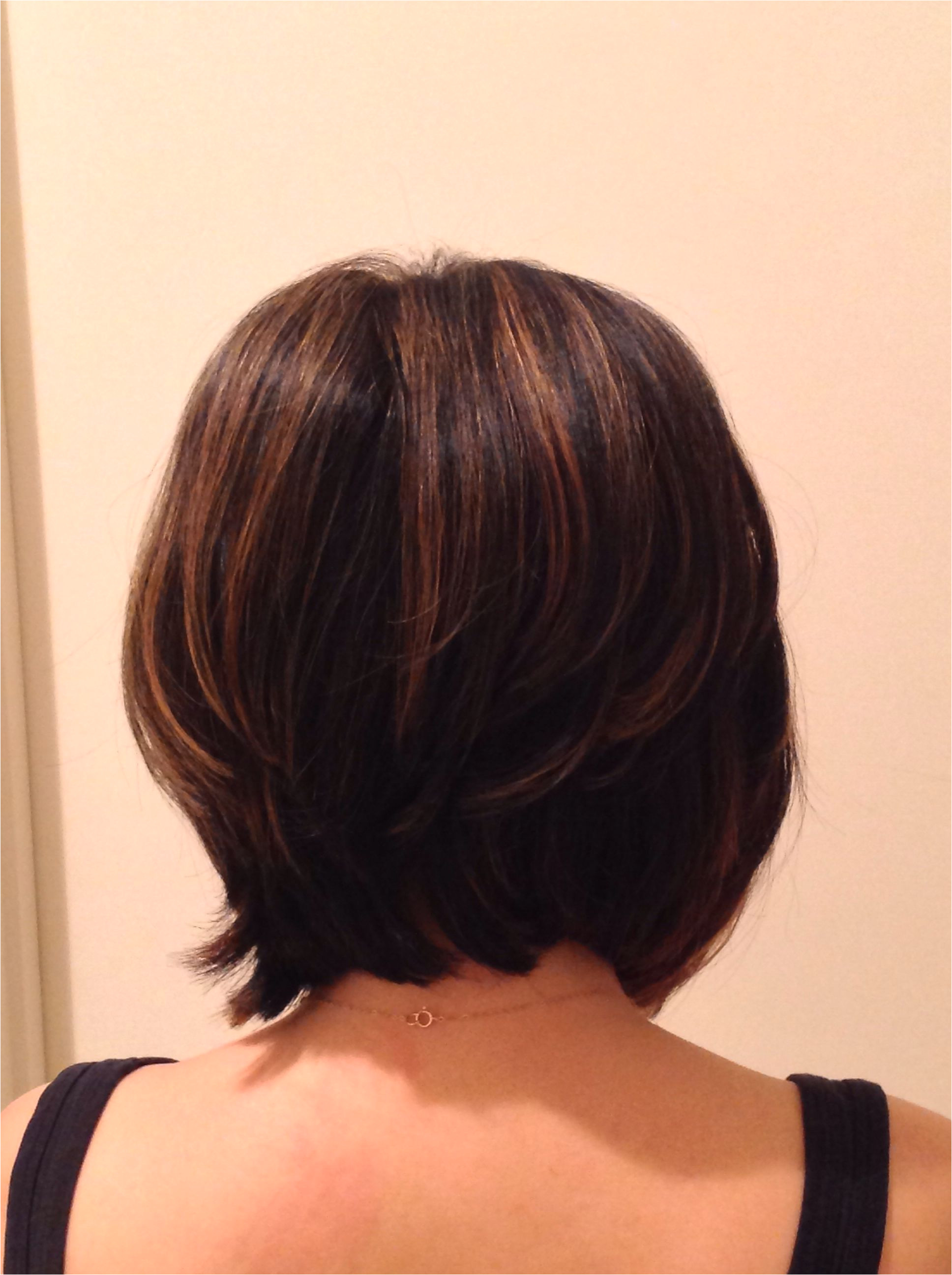 A line bob cut from back with highlights on brunette hair