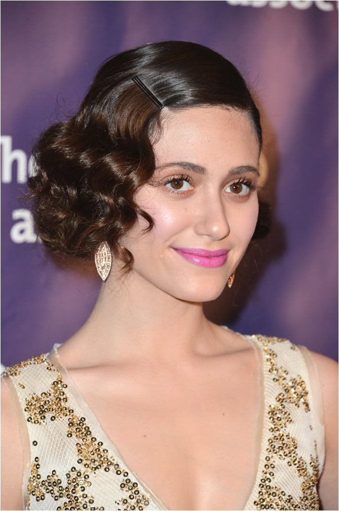 A bobby pin snuck right above a bevy of curls just as Emmy Rossum styled her waves in March is a modern twist on a classic Gatsby look