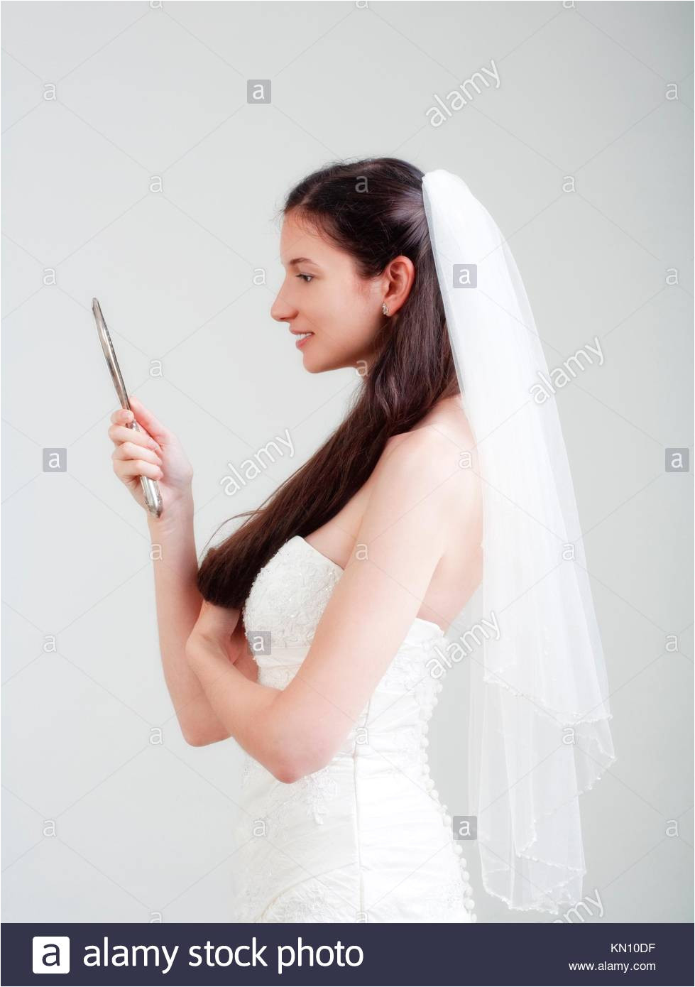 portrait od a bride with long dark hair in wedding dress isolated on gray
